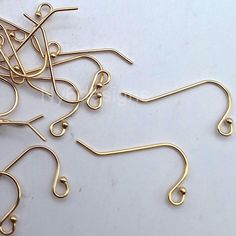 several pairs of metal hooks on a white surface