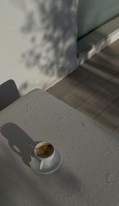 a cup of coffee sitting on top of a white table