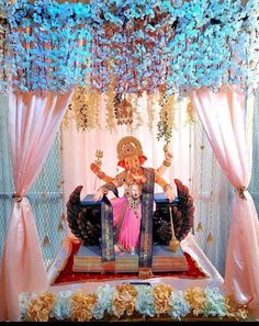 an idol sitting on top of a bed covered in flowers