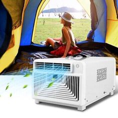 a woman sitting in front of a tent next to a small air conditioner