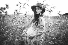 black and white photo of woman in field with flowers