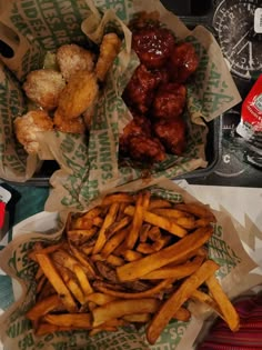 two baskets filled with french fries next to other foods