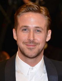 a close up of a person wearing a suit and tie with a smile on his face