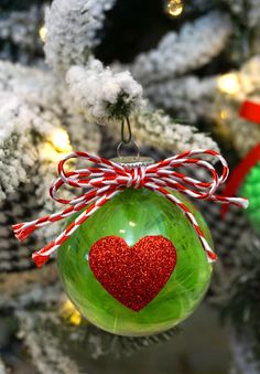 a green ornament with a red heart on it