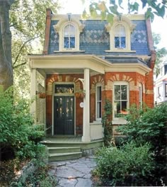 a brick house with a black front door and steps leading up to the front door