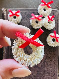 someone is holding out their hand to show off some cupcakes with bows on them