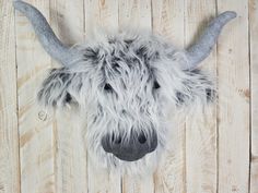 a wooly animal head mounted on a wooden wall next to a wood plank floor