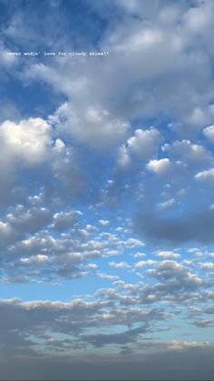 an airplane is flying in the sky with some clouds above it and another plane on the ground