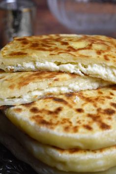 three flat breads stacked on top of each other in front of a glass container