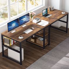 a computer desk with two monitors and a laptop on it in front of a window