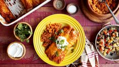 an overhead view of mexican food on a table with other dishes and utensils