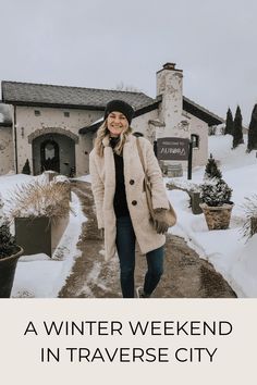 a woman standing in front of a building with the words winter weekend in traverse city