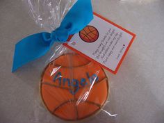 a cookie shaped like a basketball with a blue ribbon around it and an orange ball on top