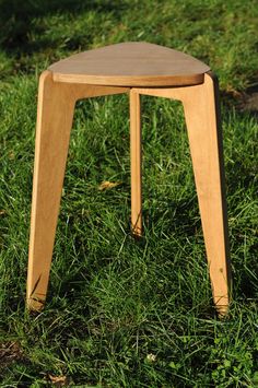 a small wooden stool sitting in the grass