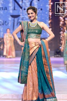 a woman in a green and gold lehenga on the ramp at a fashion show