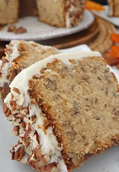 a piece of cake with white frosting and nuts on it sitting on a plate