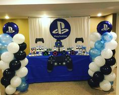 a video game themed birthday party with balloons and streamers on the table, along with a playstation logo