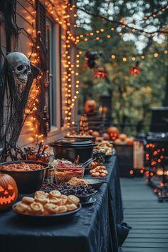 an outdoor halloween party with pumpkins, cookies and other treats on a table outside