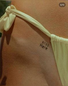 a woman's back with the words kiss hera written on it and a white ribbon