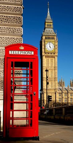 a red phone booth in front of the big ben clock tower