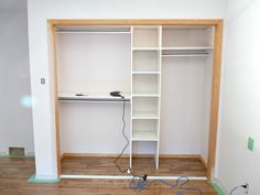 an empty room with some shelves and wires on the floor in front of it that is being worked on