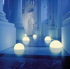 some white lights are on the floor in a room with blue walls and marble floors