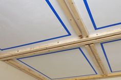 an unfinished ceiling with blue tape on it