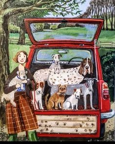 a woman standing in the back of a red car with dogs on it's trunk