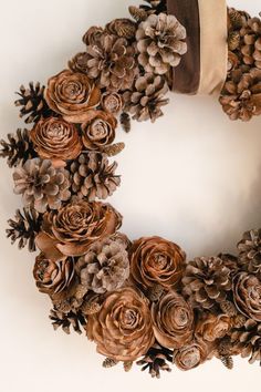 a wreath made out of pine cones and flowers