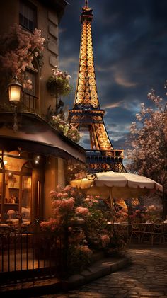 the eiffel tower is lit up at night with pink flowers and trees around it