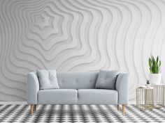 a blue couch sitting in front of a white wall with wavy designs on it's walls