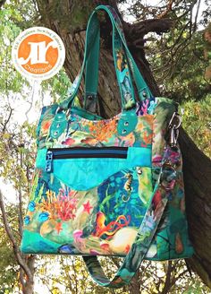 a handbag hanging from the side of a tree with an image of fish and corals on it