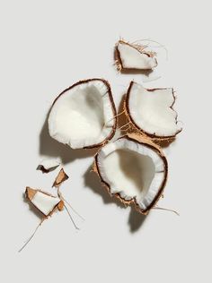 coconuts are cut in half on a white surface with the peel removed from them