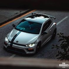 a silver sports car driving down a street