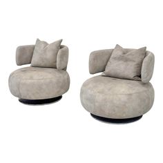 two grey chairs with pillows on them sitting next to each other