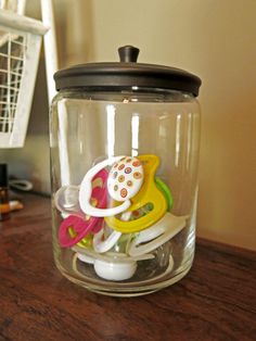 a glass jar filled with toys on top of a wooden table