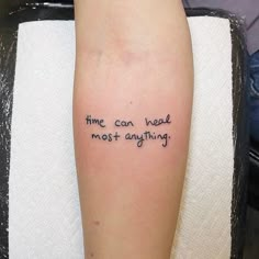 a person with a tattoo on their arm that says time can heal most anything,