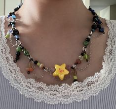 a close up of a woman wearing a necklace with beads and charms on it's neck