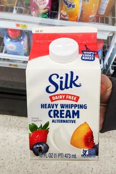 a person holding up a carton of dairy