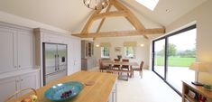 a large kitchen with an island in the center and glass doors leading to another room