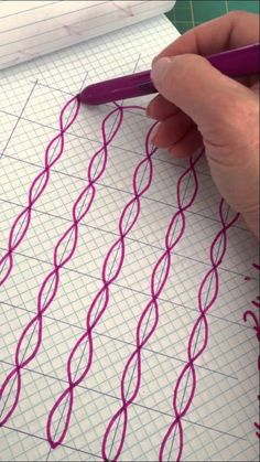 someone is drawing lines on paper with a purple pen