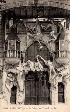 an old black and white photo of the front entrance to a building with statues on it