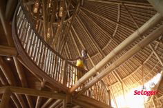 the inside of a bamboo hut with people climbing up and down it's roof