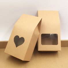 two brown boxes with black heart cutouts on the inside and one has a window in it