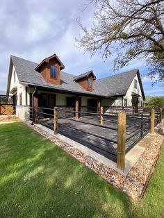 a house with a fence in front of it and grass on the ground next to it