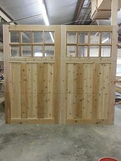 two wooden doors with windows in a garage