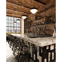 an industrial style bar with marble counter tops and stools