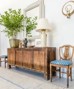 a wooden cabinet sitting next to a lamp on top of a table