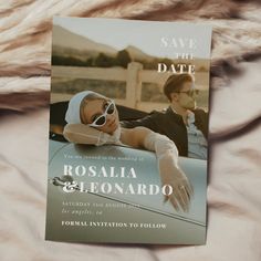 a wedding save the date card sitting on top of a furnishing blanket with two men in sunglasses