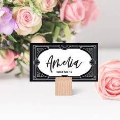 a table name sign with pink flowers in the background